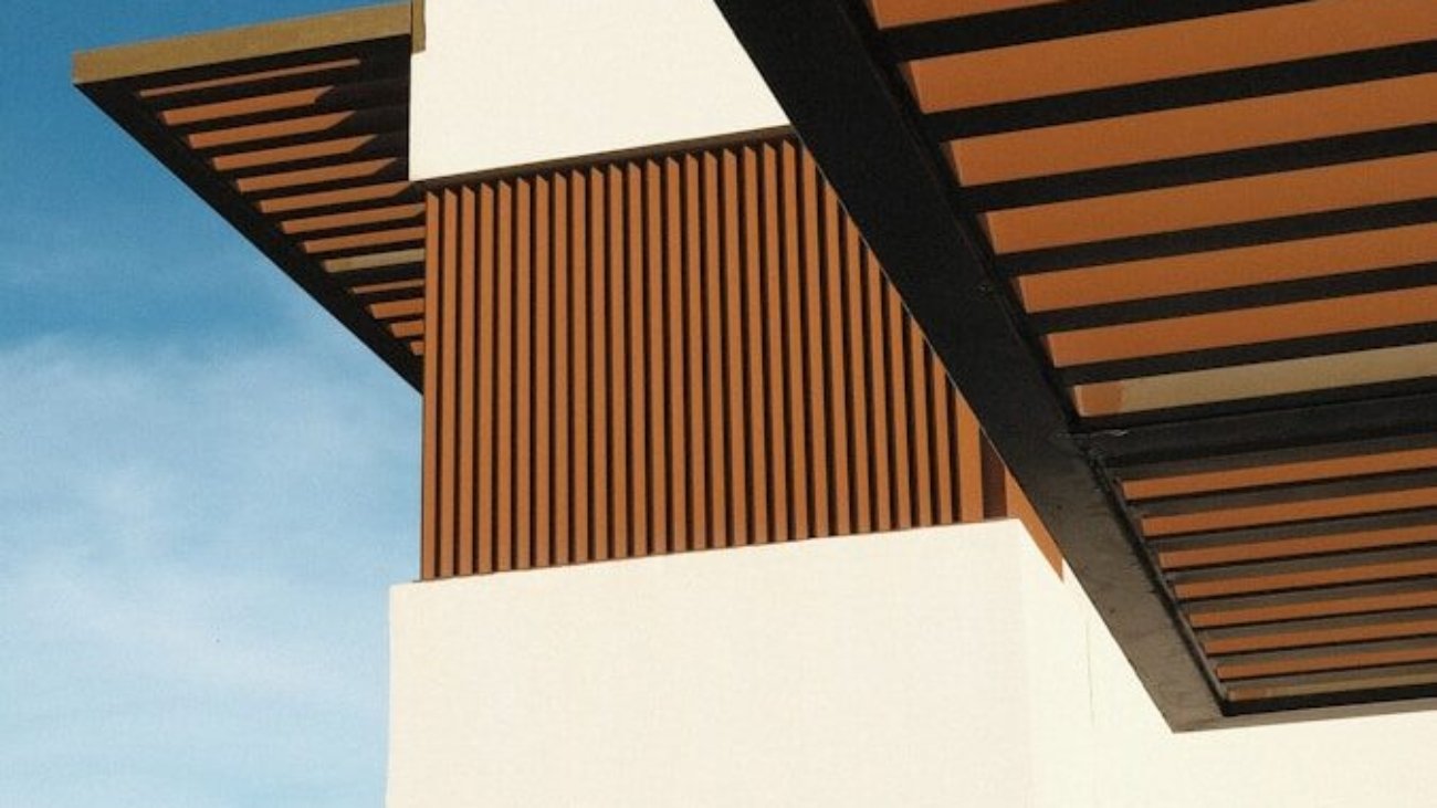 a white building with a wooden roof and a sky background