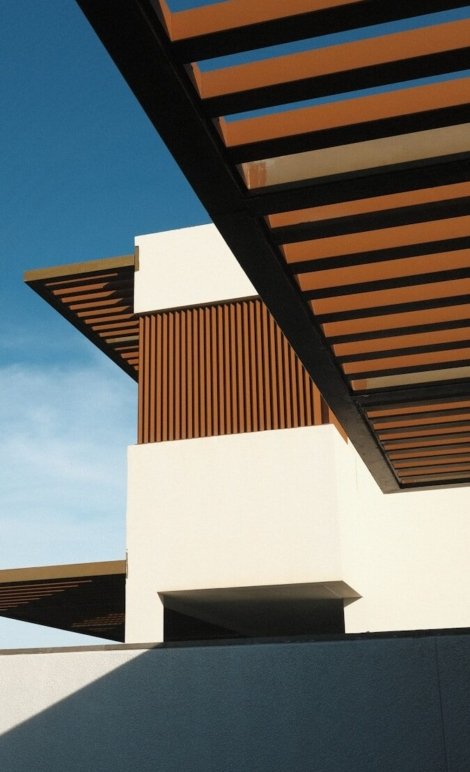 a white building with a wooden roof and a sky background