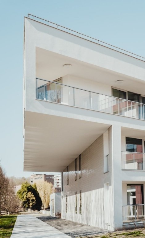 white concrete residential building near trees