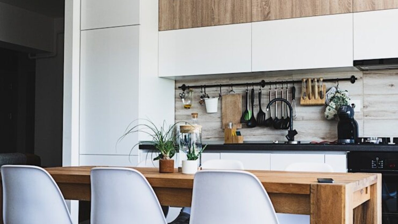 brown wooden dining table with white chairs near kitchen