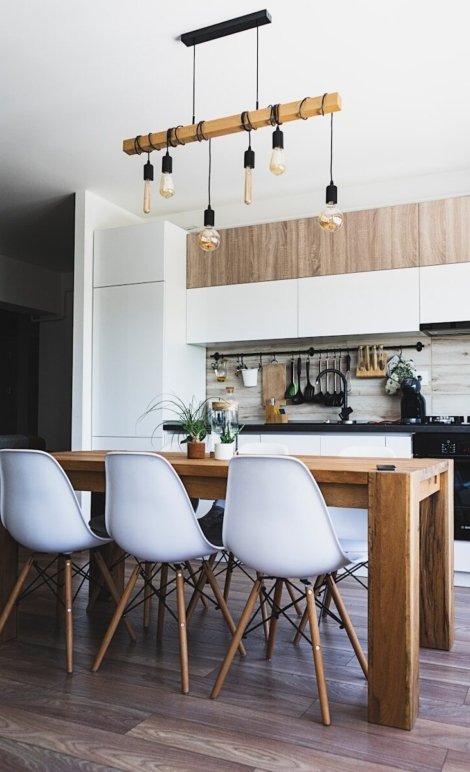 brown wooden dining table with white chairs near kitchen